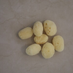 Natural sea sponge collection on a beige background showcasing soft texture. Ideal for eco-friendly bathing and skincare routines highlighting sustainability and natural beauty.